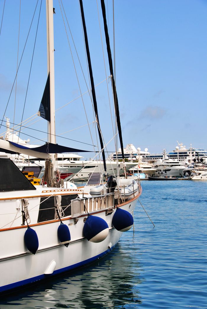 A scenic view of luxury yachts in Monacos marina under a clear blue sky.