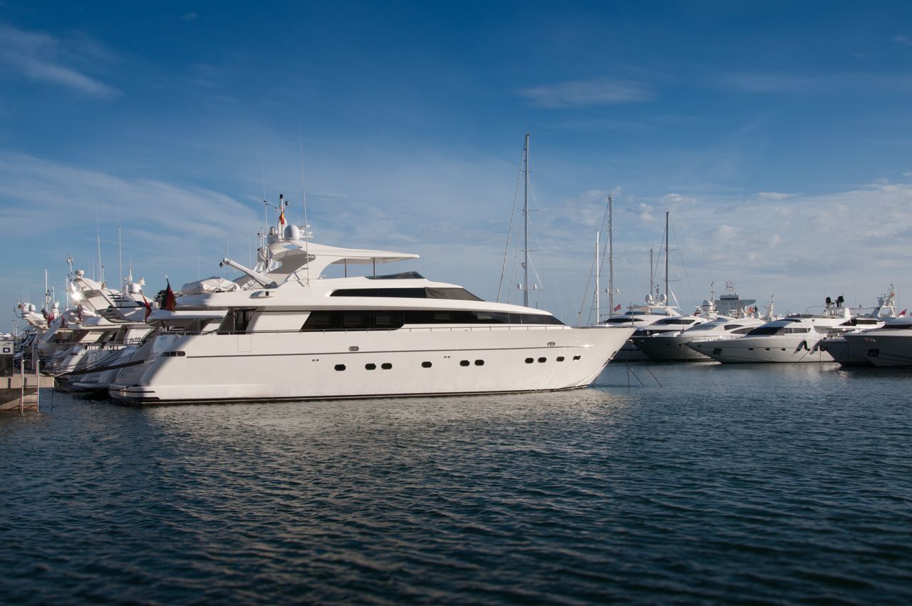 Services-02 A serene marina scene featuring luxury yachts docked under a clear blue sky.