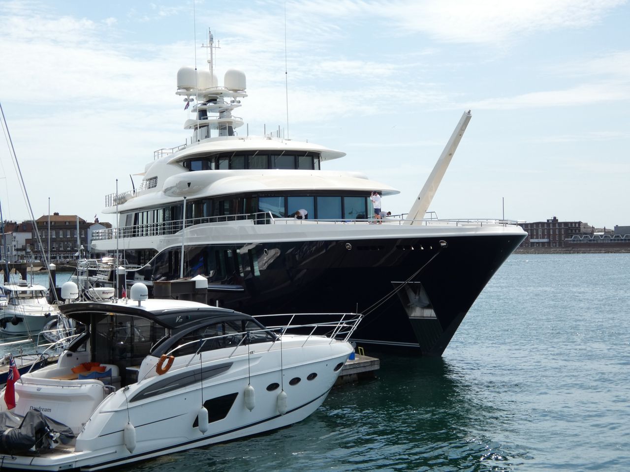 creative A luxurious yacht docked at Portsmouth Marina under a clear blue sky.